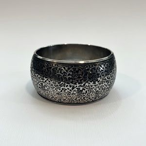 Cuff bracelet with floral pattern relief.